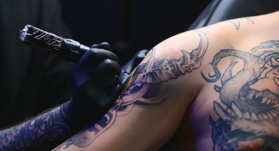 Tattoo artist hands wearing gloves and holding a tattoo machine Tattoo artist hands wearing gloves and holding a tattoo machine.