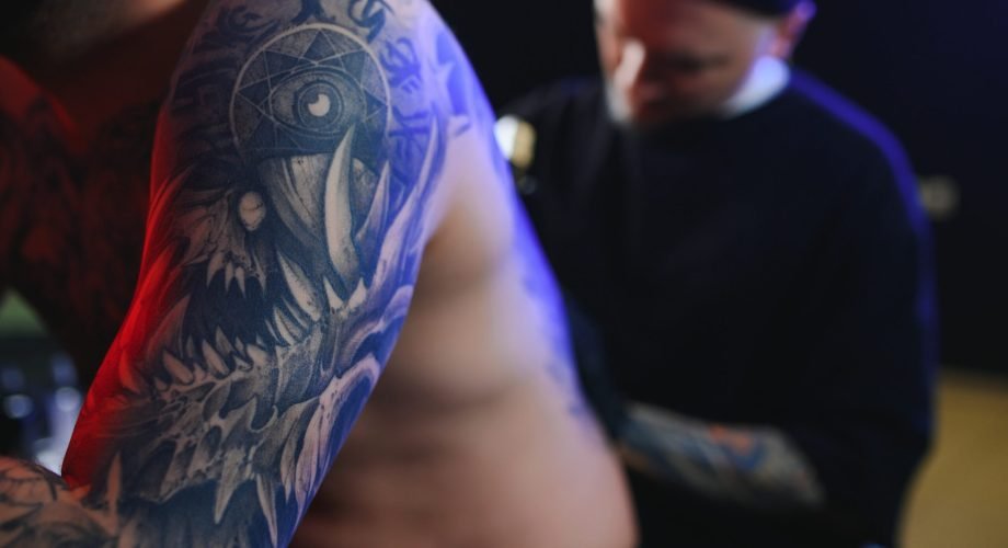 Tattooing. Man creating a picture on his back by a professional tattoo artist Tattooing. Man creating a picture on his back by a professional tattoo artist.