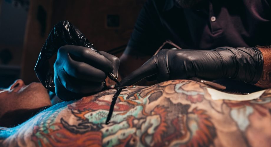 There i no only one tattoo Cropped shot of an artist hands in a protective gloves holding ma machine while the ink is dropping